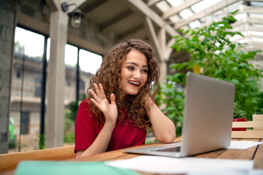 Young woman sitting indoors in green office, conference business call concept